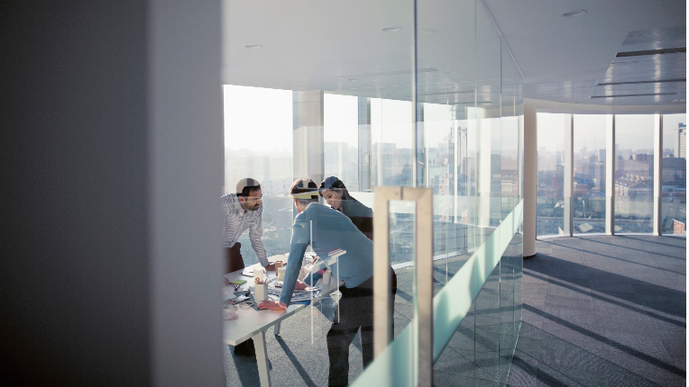 a team discussing while standing over a table