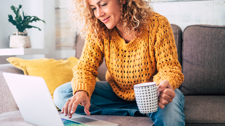 Woman on a couch looking at her laptop