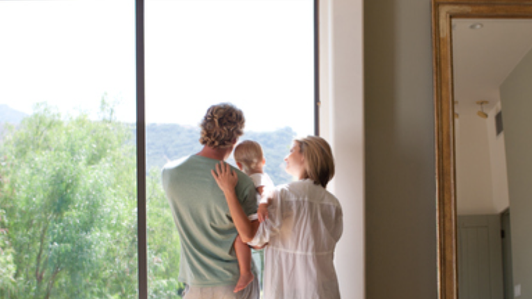 Couple and baby son looking out window