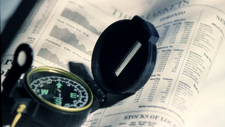 Picture of a compass sitting on a newspaper