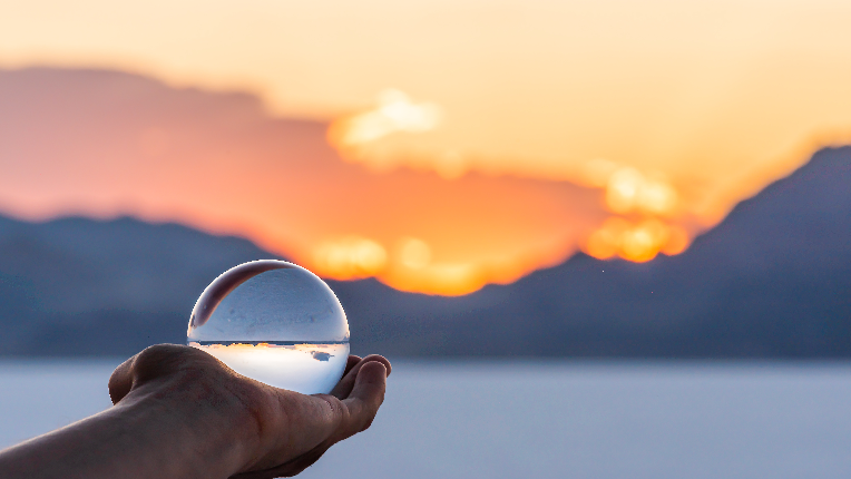 Hand holding a glass globe.
