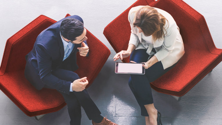 People sitting on a couch looking at a screen.