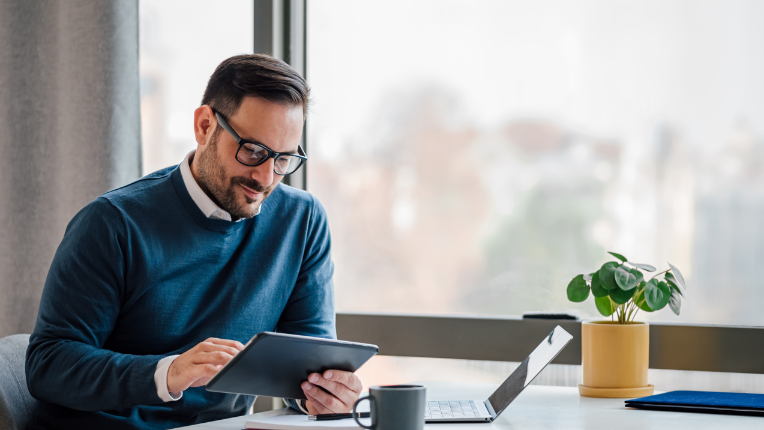 Homme à table avec une tablette.