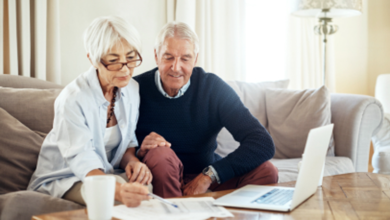 Two older people looking at a laptop.