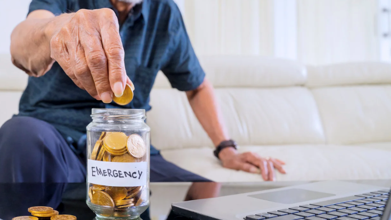 Man putting coins in a jar labelled emergency