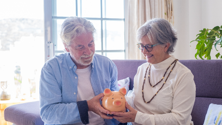 Senior couple holding piggy bank