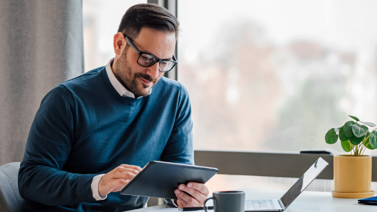 Homme à table avec tablette.