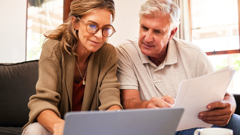 Two people reviewing taxes on laptop.