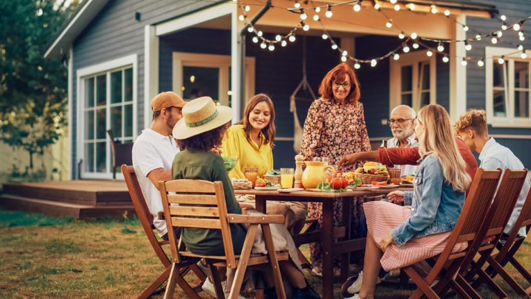 People having a lunch outside in the backyard.