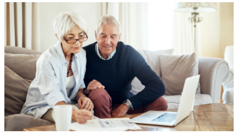 Couple working on paperwork in front of a laptop