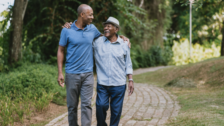 Senior father and adult son having a conversation in the park.