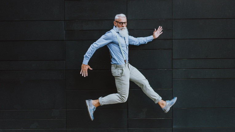 A senior man leaps from work to retirement