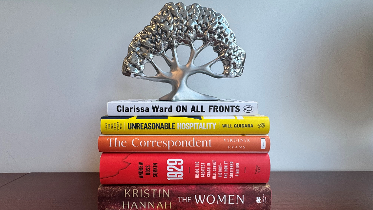 Stack of books with roots of growth tree on the top
