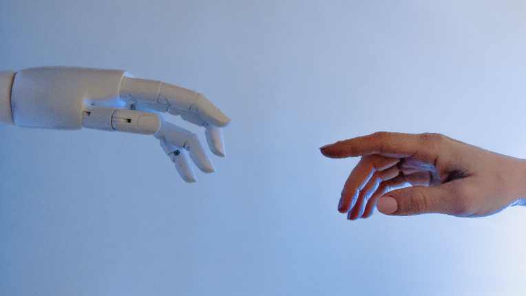 robot hand and human hand reaching for each other