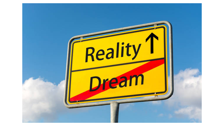 Sign showing the word reality with arrow pointing up, and the word dream crossed out