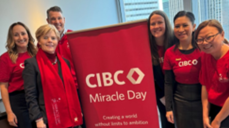 Team poses with CIBC Miracle Day sign