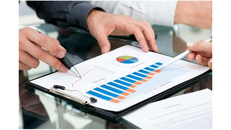 a persons hands pointing to a chart using a pen