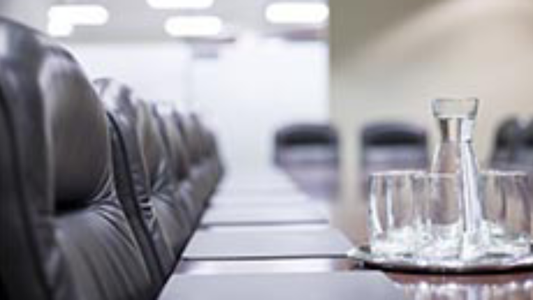 Conference table with chairs with a decanter and some glasses of water