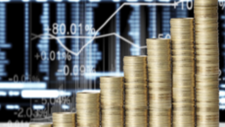 Coins stacked in front of charts and graphs