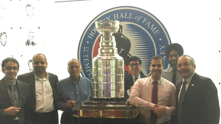 Ankit, Peter and other people stood around a hockey triumph at Toronto Hockey Hall of Fame