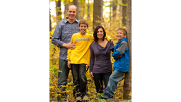 The Lockhart family standing in the woods