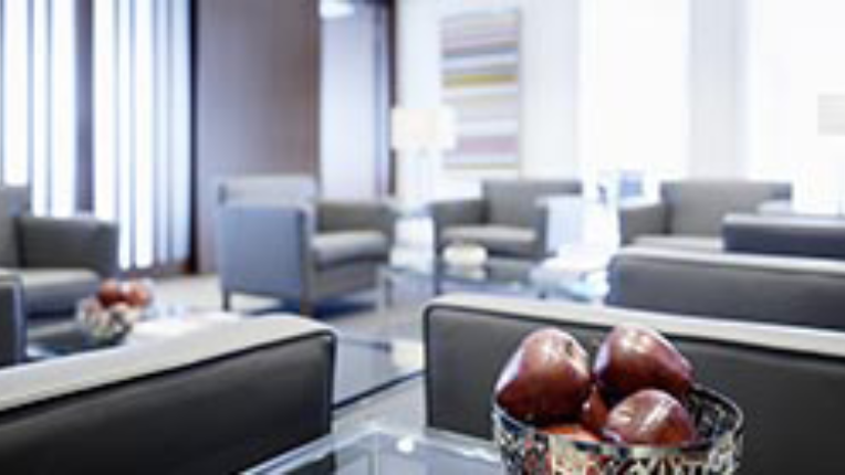 Room full of chairs and tables with a bowl of apples on each table