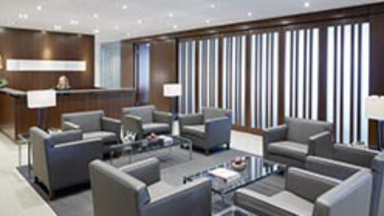 Room full of grey chairs and tables in a lobby