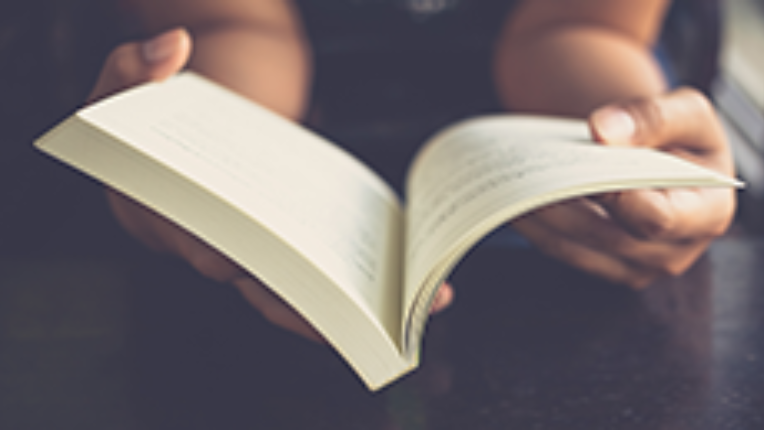 A hand opening a book