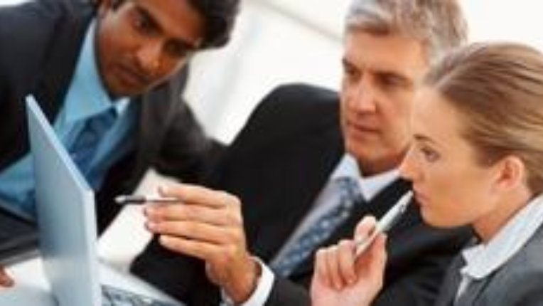 Three people looking at a laptop screen together