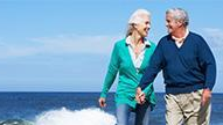 Elderly couple walking on the beach