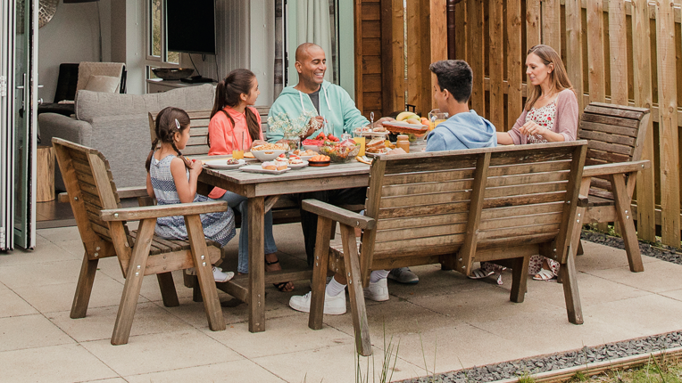 Family having their breakfast outside the holiday cottage