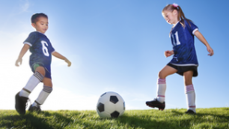 Two kids playing football.