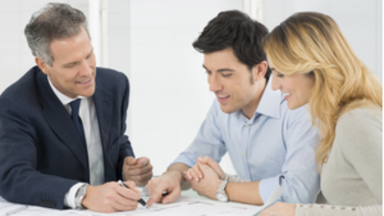 an advisor sitting with a couple to review taxes