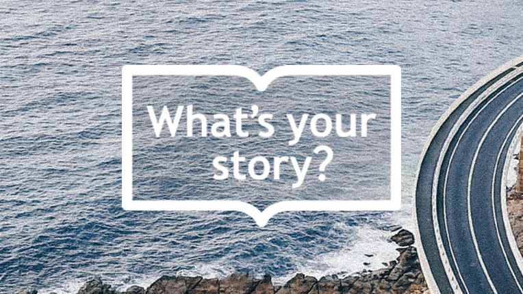 A meandering road overlooking ocean, with text overlaid indicating, What's Your Story?