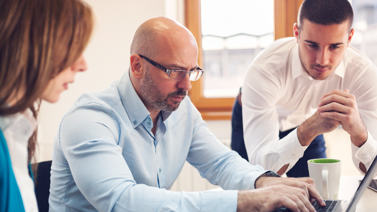 Group of people looking at a laptop