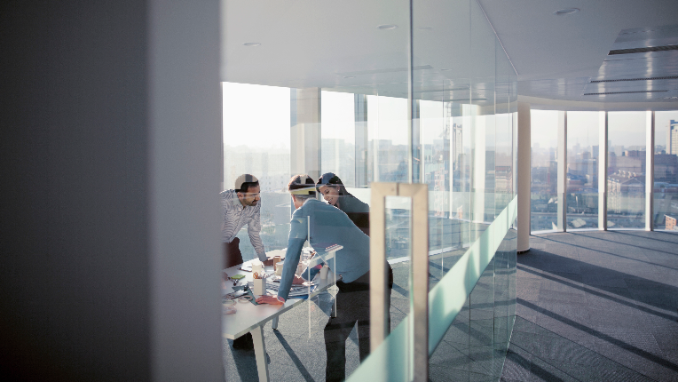 A man and women discussing over a table in an office