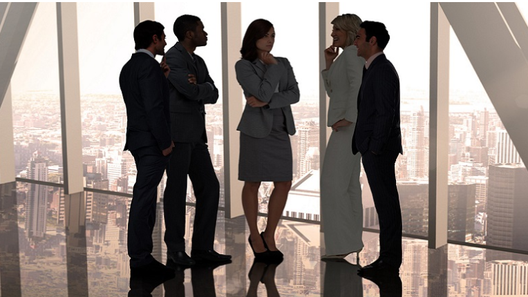 a group of professionals standing in front of a floor to ceiling window.