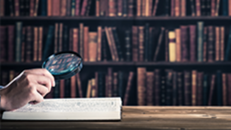 a hand looking at a book in a library