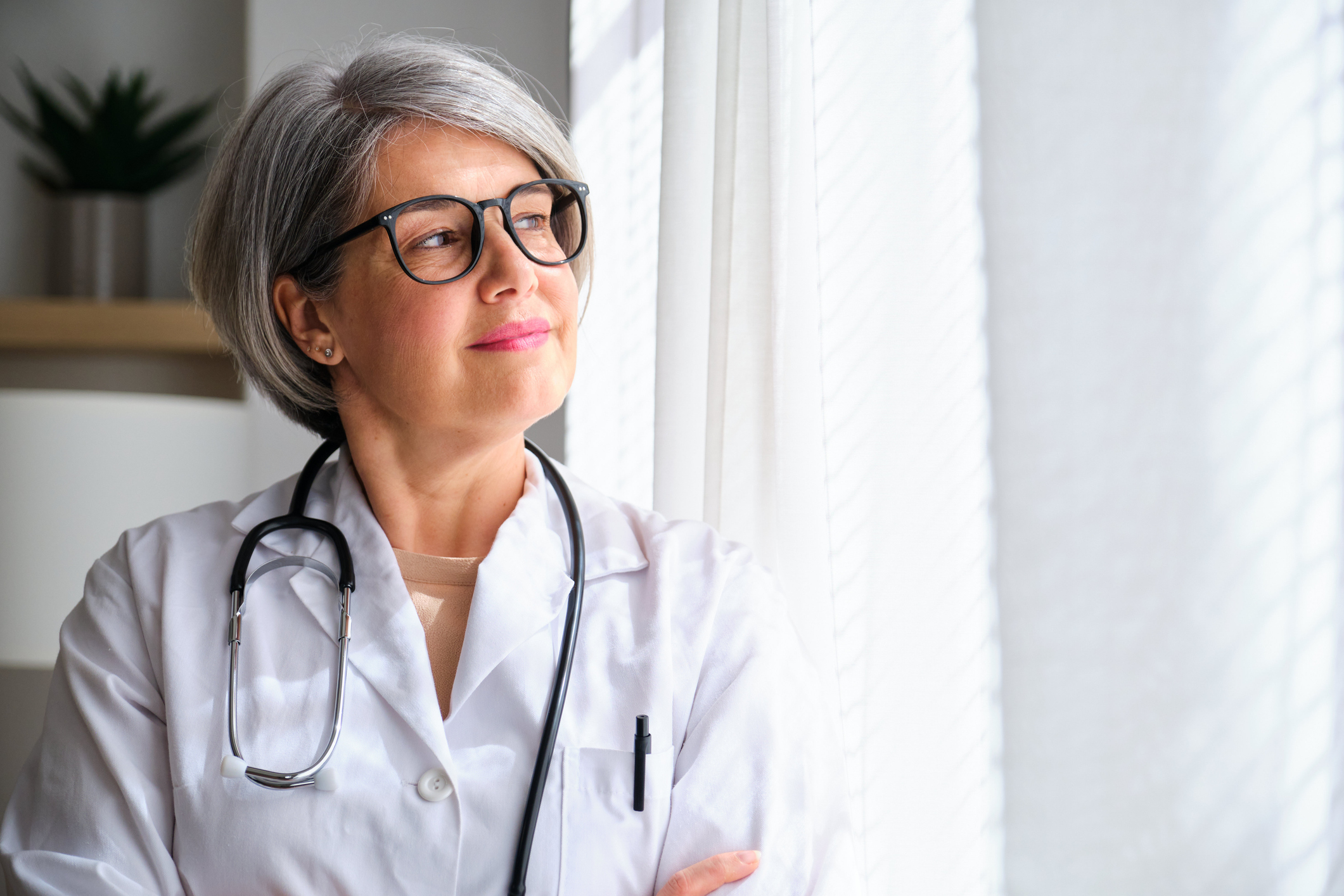 elderly woman doctor looking out a window