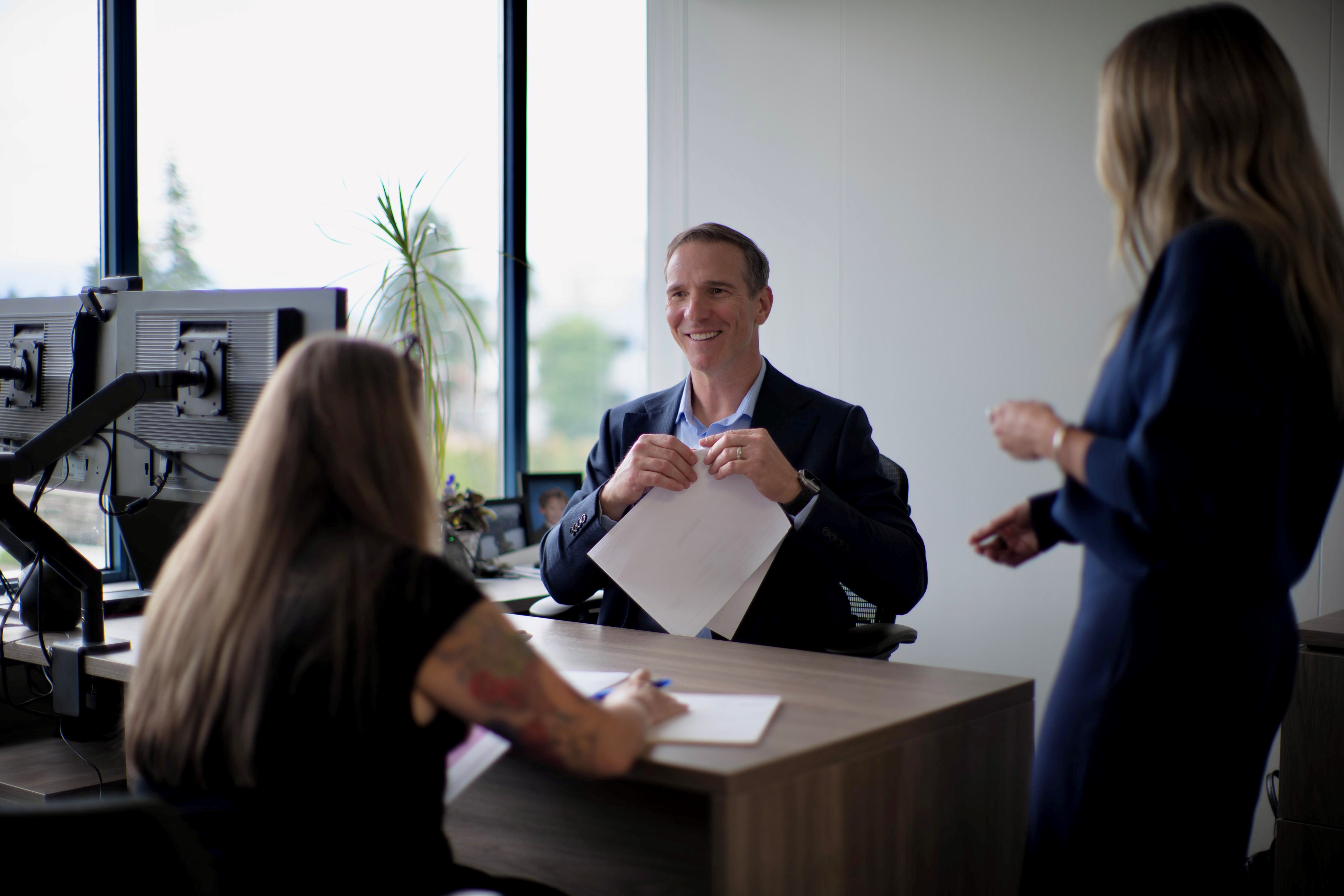 Brent at his office desk with Chantelle and Tracey