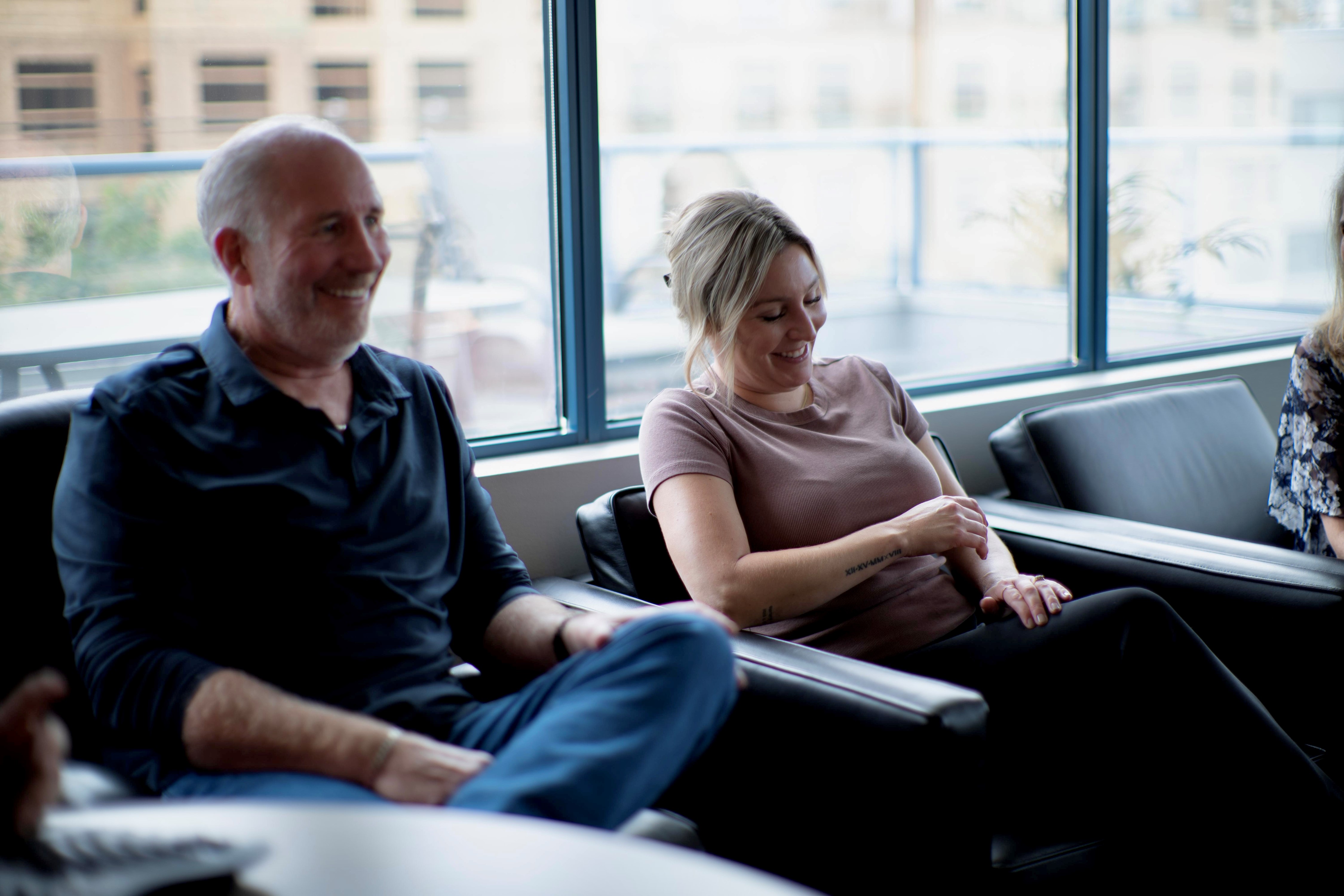 Cam and Jill sitting in boardroom chatting