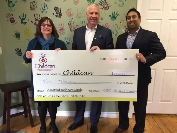 Fraser Standing with $5,000 cheque to Childcan.