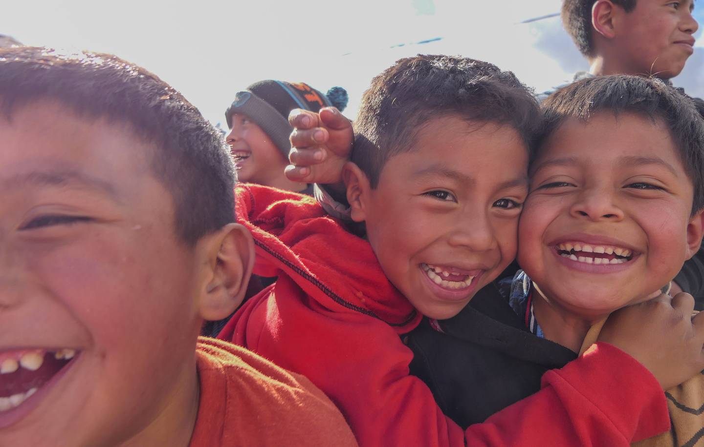 Several children are closely grouped smiling together