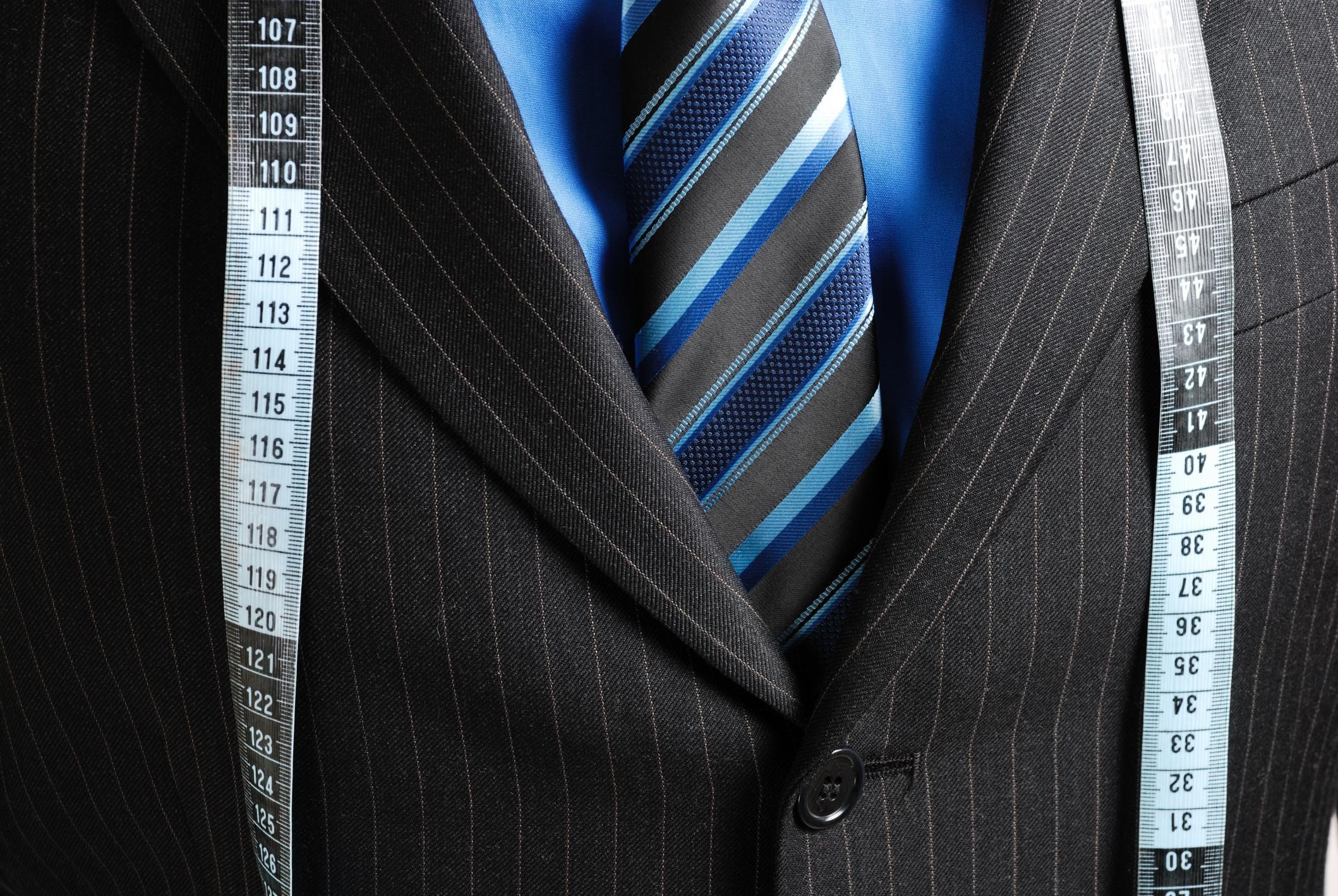 close up of the chest of a suit jacket with a tailor's tape.
