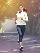 Woman jogging in the side of the road 