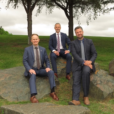 Paul Johnston, Tyler Hynnes, and Fred Brown sitting on a rock
