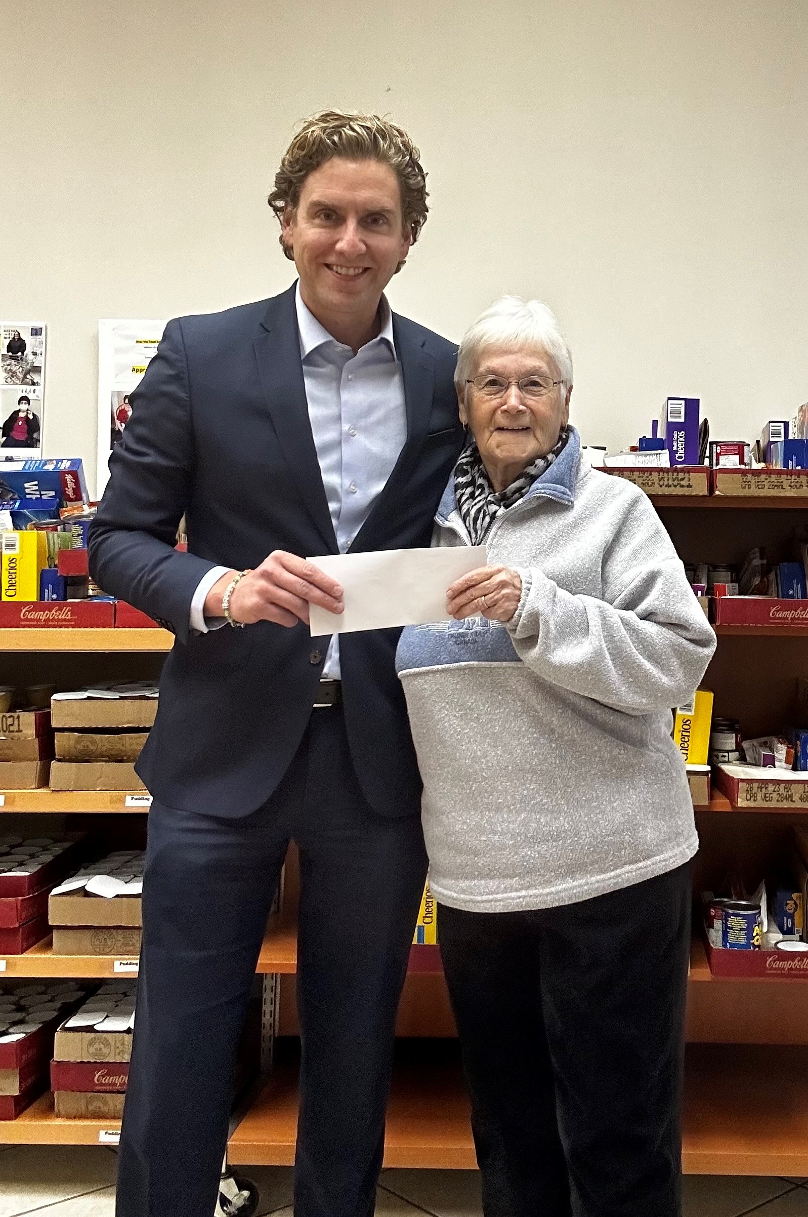 Mark Casey presenting After the School Bell's President, Doris Walton, with a cheque for $5,000 raised on CIBC Miracle Day.