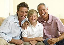 a son, father and grandfather sitting on a couch smiling